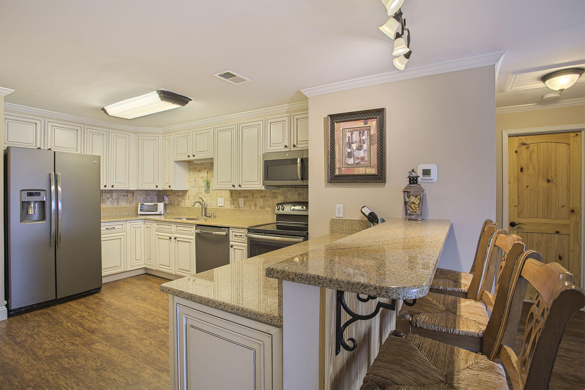 195 Durango Road, Unit 3D Destin, FL 32541 - Photo 5 of 22 a kitchen with a refrigerator a stove a sink dishwasher a dining table and chairs with wooden floor