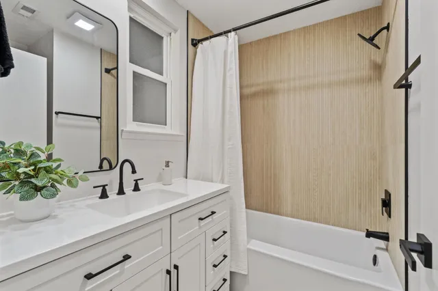 a bathroom with a sink a mirror a vanity and a shower