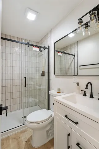 a bathroom with a sink a toilet and shower