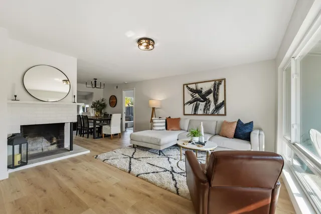a living room with furniture a fireplace and a large window