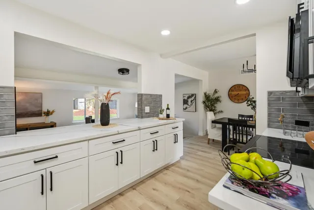 a kitchen with stainless steel appliances granite countertop a sink and a white cabinets
