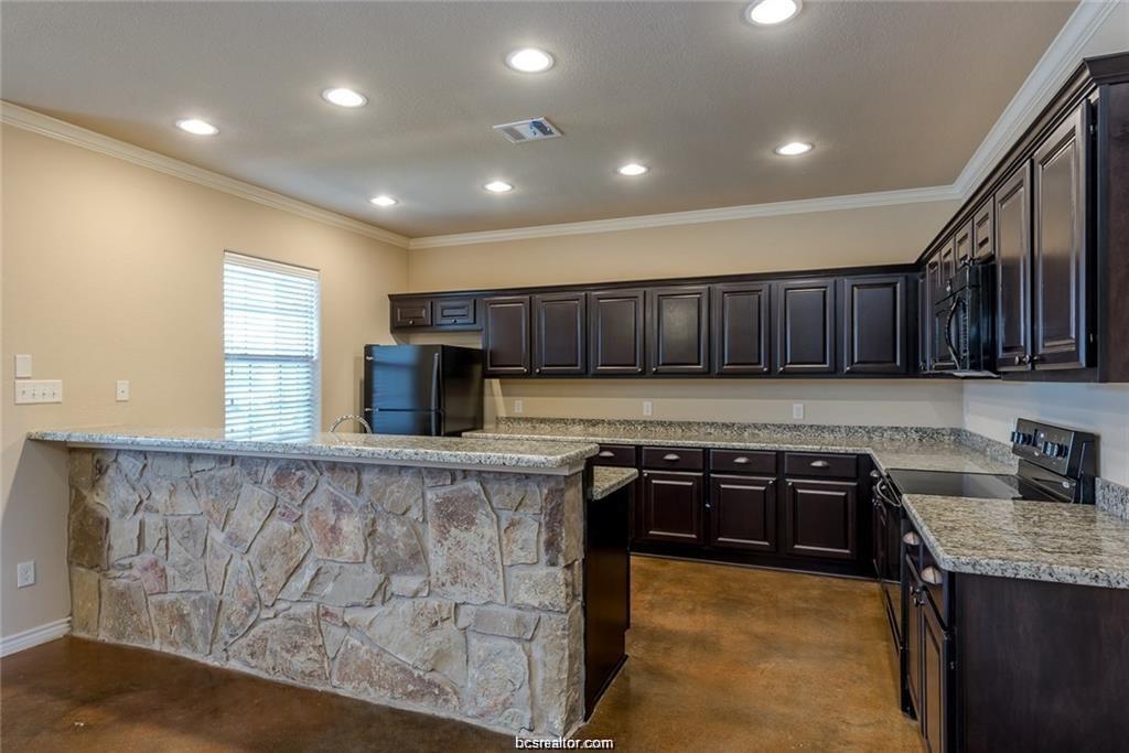 4321 Commando Trail College Station, TX 77845 - Photo 4 of 12 a kitchen with wooden cabinets and a sink
