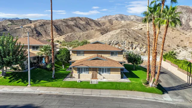 a view of a house with a yard and potted plants