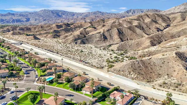 an aerial view of a city with lots of residential buildings and mountain view in back