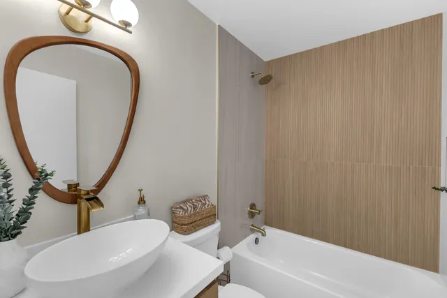 a bathroom with a sink a toilet and a mirror