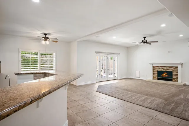 a view of an empty room with a window and a fireplace