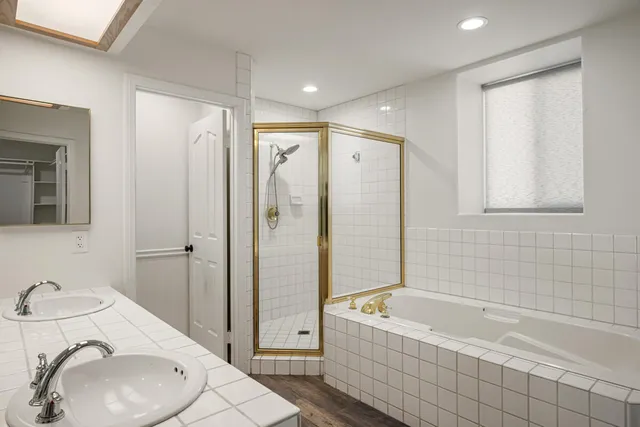 a bathroom with a granite countertop bathtub shower sink vanity and mirror