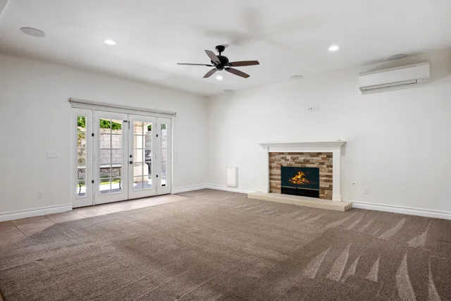 an empty room with fireplace and windows