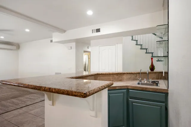 a bathroom with a granite countertop sink and a mirror