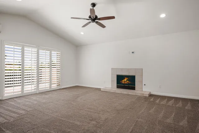 an empty room with windows and fireplace
