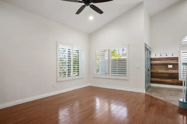a view of an empty room with a window and wooden floor
