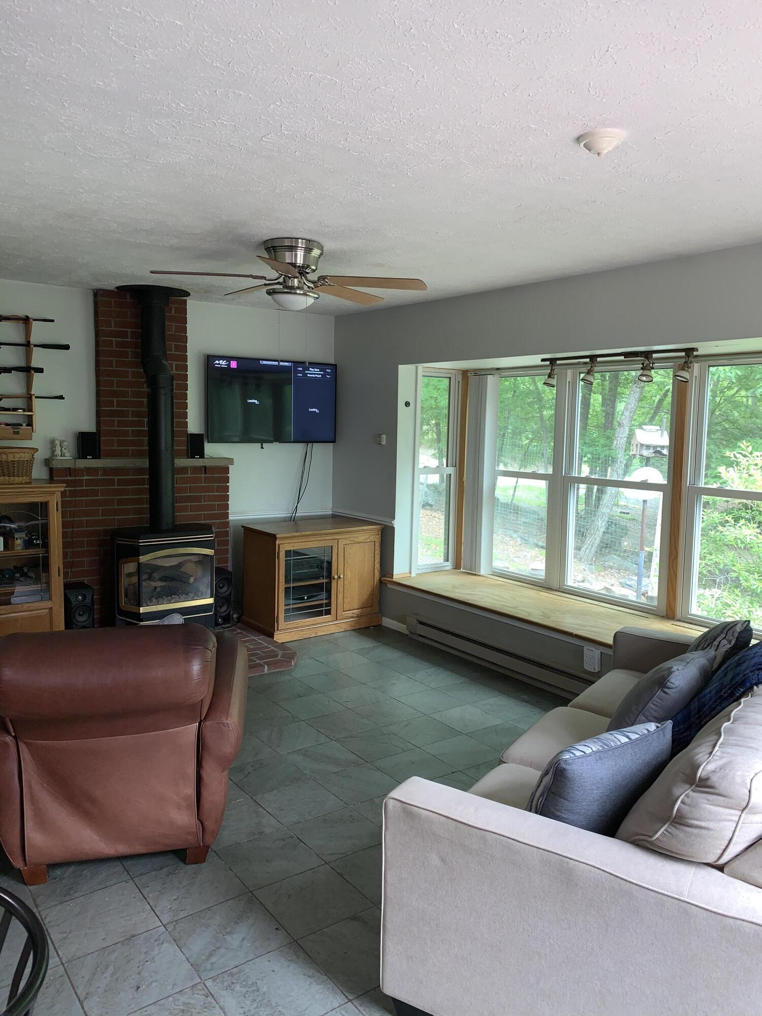 3205 Ely Court Bushkill, PA 18324 - Photo 22 of 80 a living room with furniture a fireplace and a flat screen tv