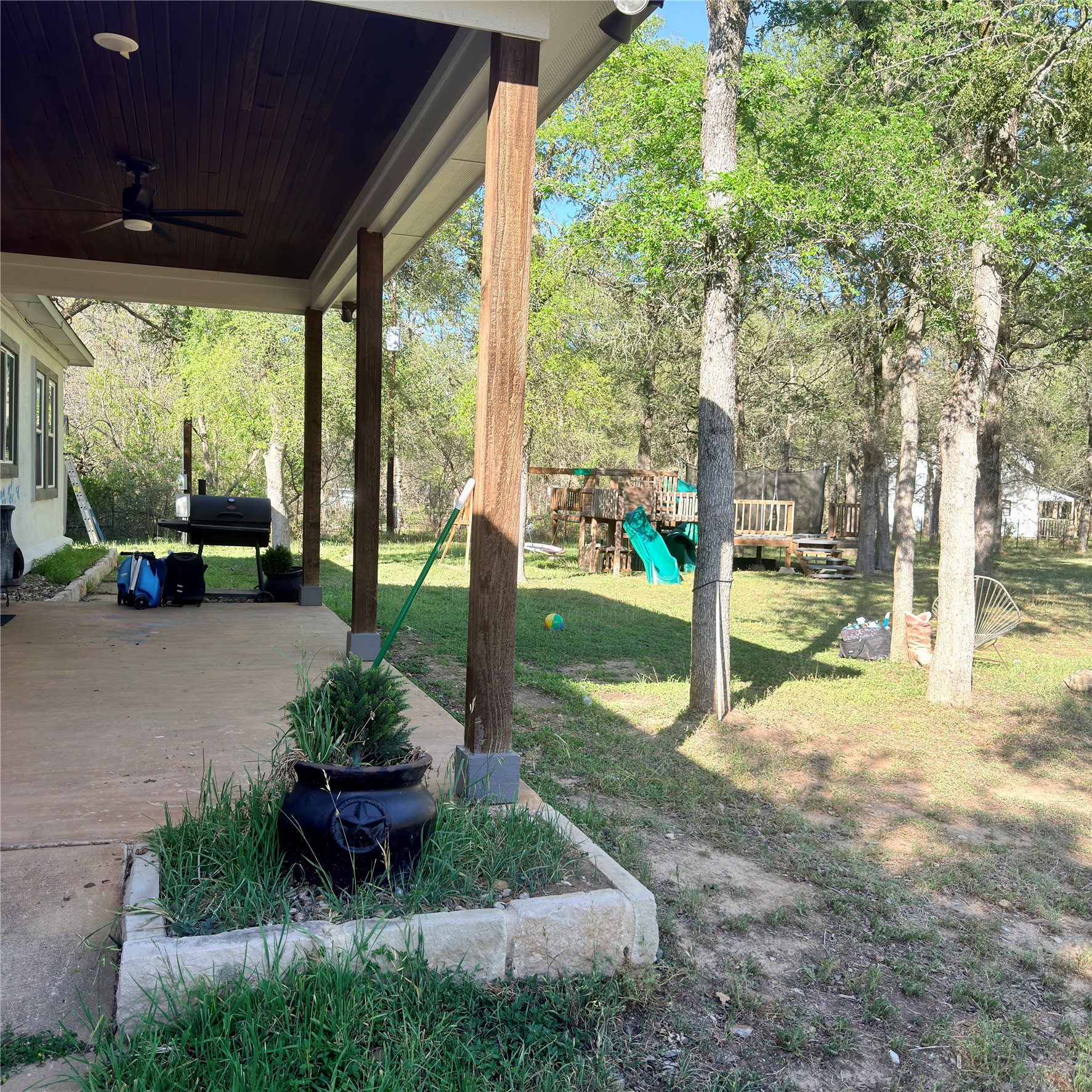 127 Comanche Trail, Unit A Elgin, TX 78621 - Photo 21 of 33 View of green lawn featuring a playground, ceiling fan, and a patio area