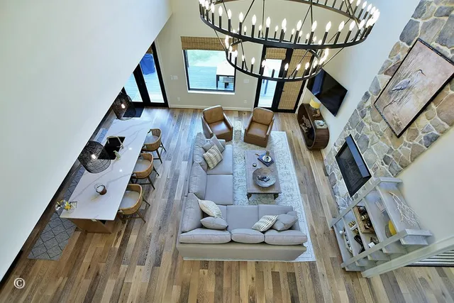 a living room with furniture a fireplace and a floor to ceiling window