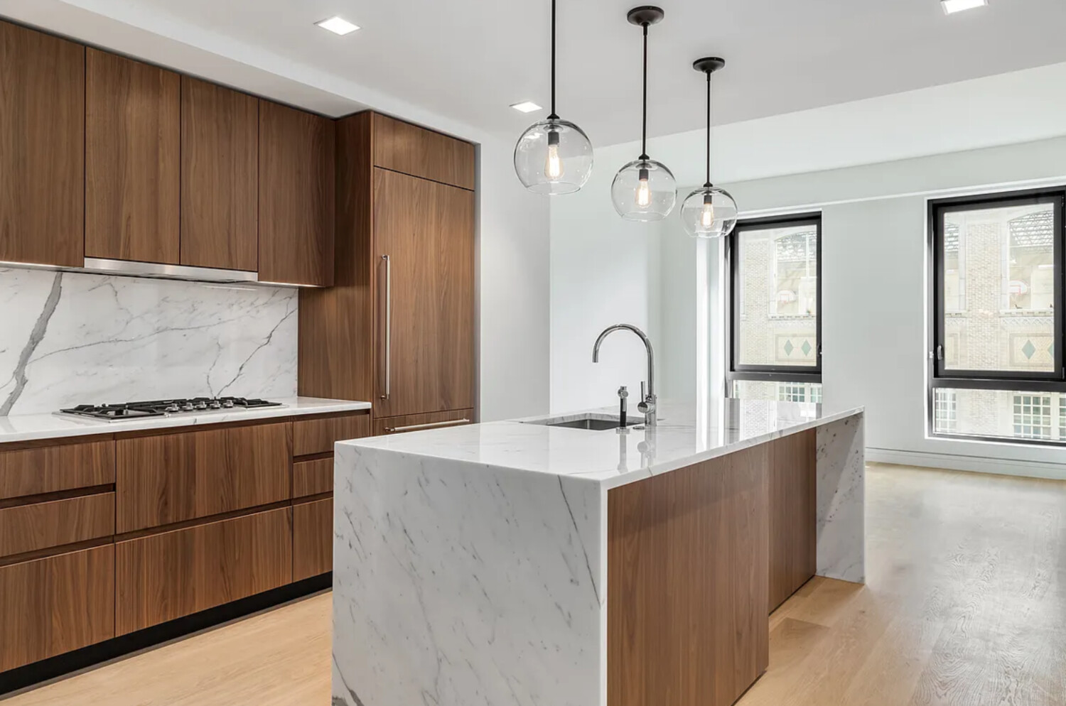 242 Broome Street, Unit 10B Manhattan, NY 10002 - Photo 1 of 10 a kitchen with stainless steel appliances granite countertop a sink a stove and a refrigerator