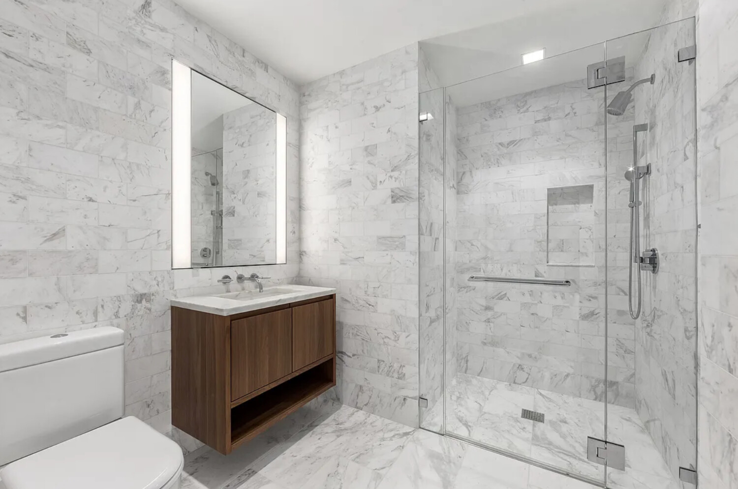 242 Broome Street, Unit 10B Manhattan, NY 10002 - Photo 3 of 10 a bathroom with a granite countertop sink a toilet and shower
