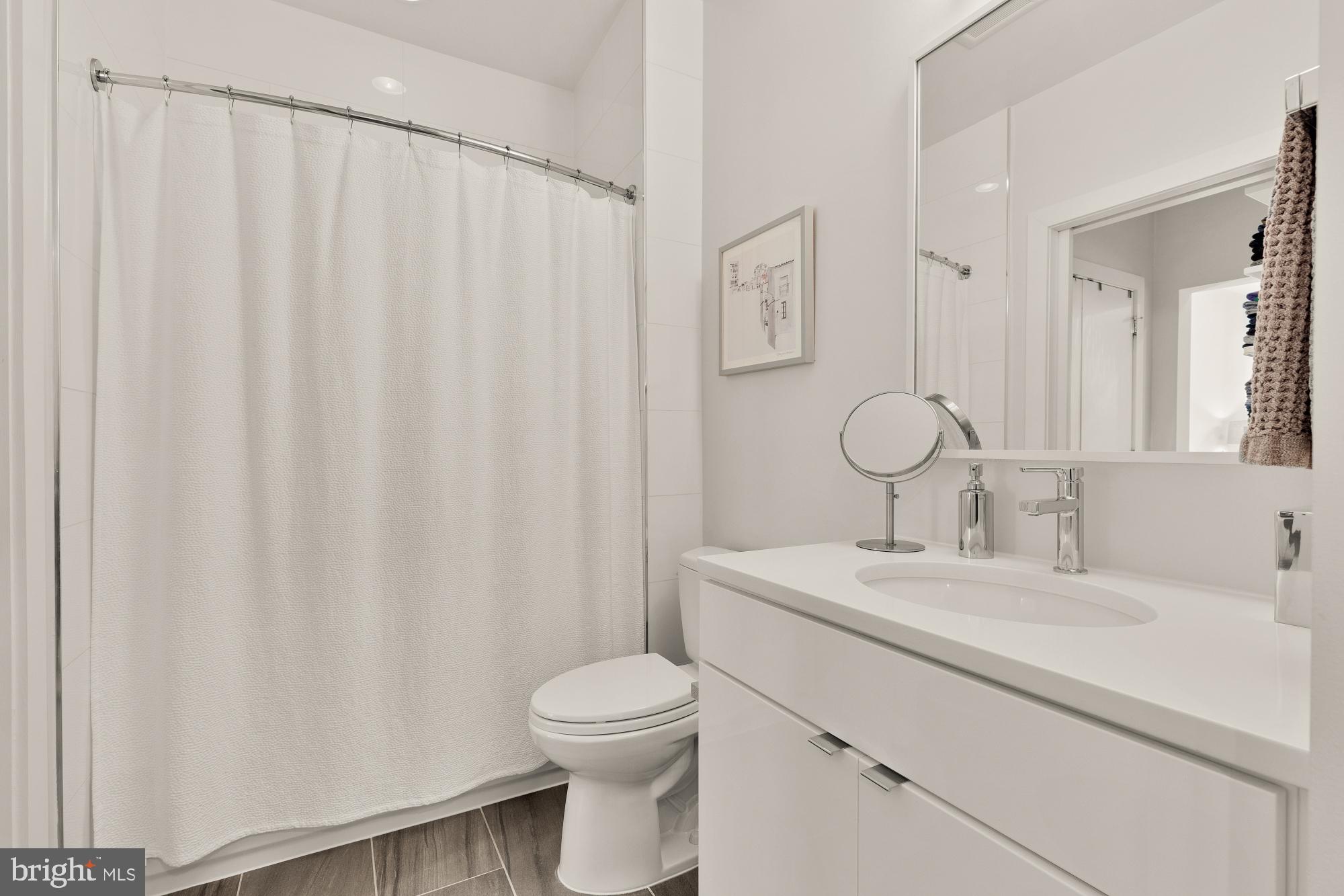 1405 W Street Northwest, Unit 203 Washington, DC 20009 - Photo 16 of 20 a bathroom with a toilet a sink and curtain