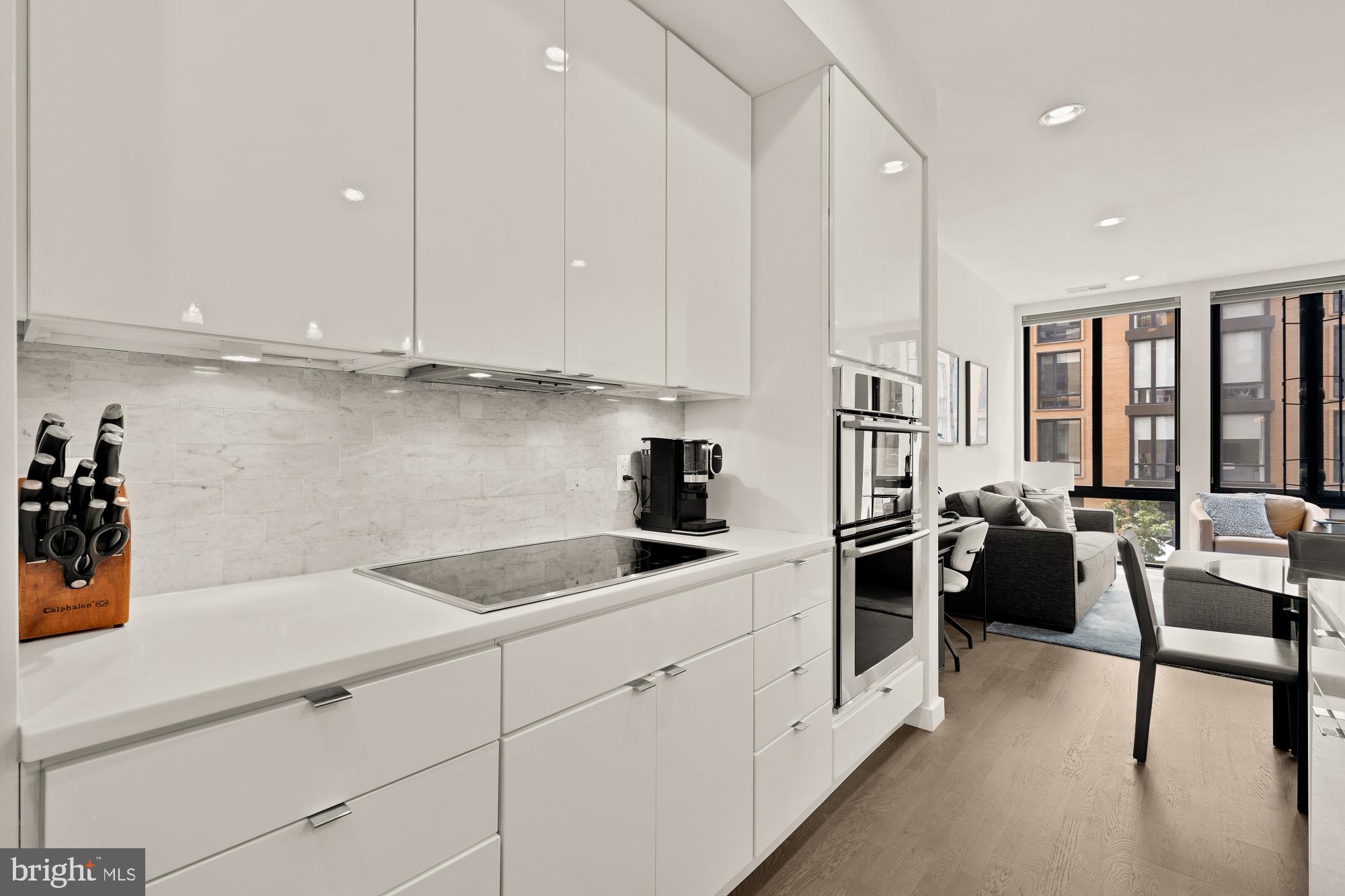 1405 W Street Northwest, Unit 203 Washington, DC 20009 - Photo 5 of 20 a kitchen with stainless steel appliances kitchen island granite countertop a refrigerator a sink and white cabinets
