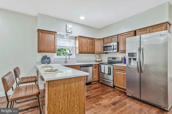 a kitchen with stainless steel appliances granite countertop a refrigerator sink and stove