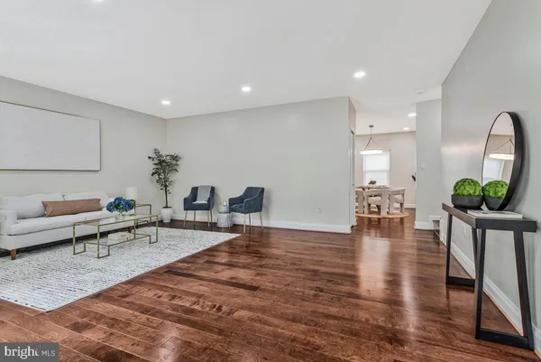 a living room with furniture wooden floor and a potted plant