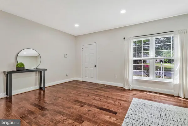 a view of empty room with wooden floor and window