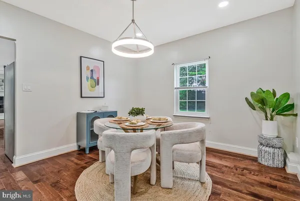 a dining room with furniture potted plants and wooden floor