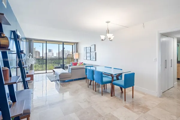 a living room with furniture a floor to ceiling window and a flat screen tv