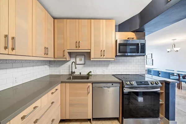 a kitchen with stainless steel appliances a stove a sink and a microwave