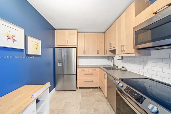a kitchen with stainless steel appliances granite countertop a refrigerator sink and cabinets