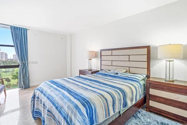 a bedroom with a bed and a lamp next to a window