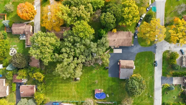 an aerial view of a residential houses with yard