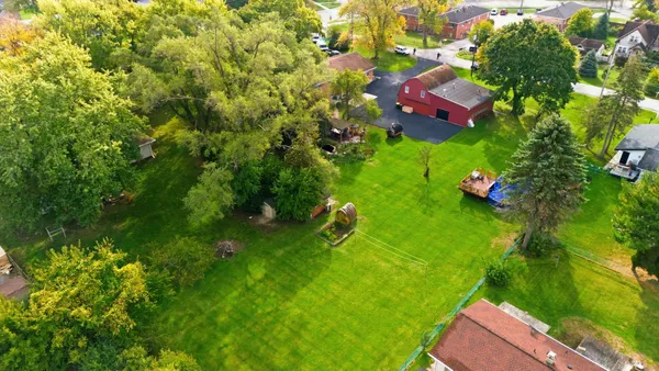an aerial view of residential house with outdoor space and trees all around