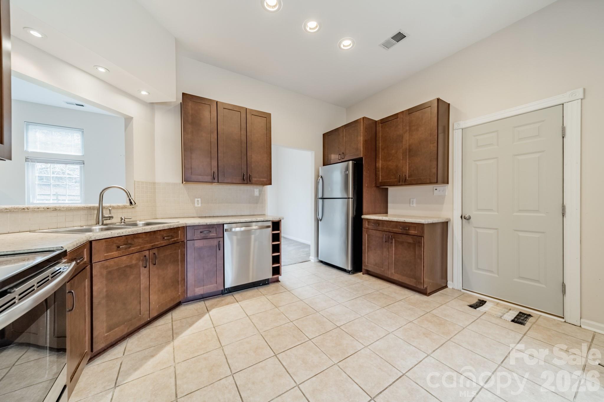 9409 Cedar River Road Huntersville, NC 28078 - Photo 16 of 31 a large kitchen with stainless steel appliances granite countertop a refrigerator and a sink