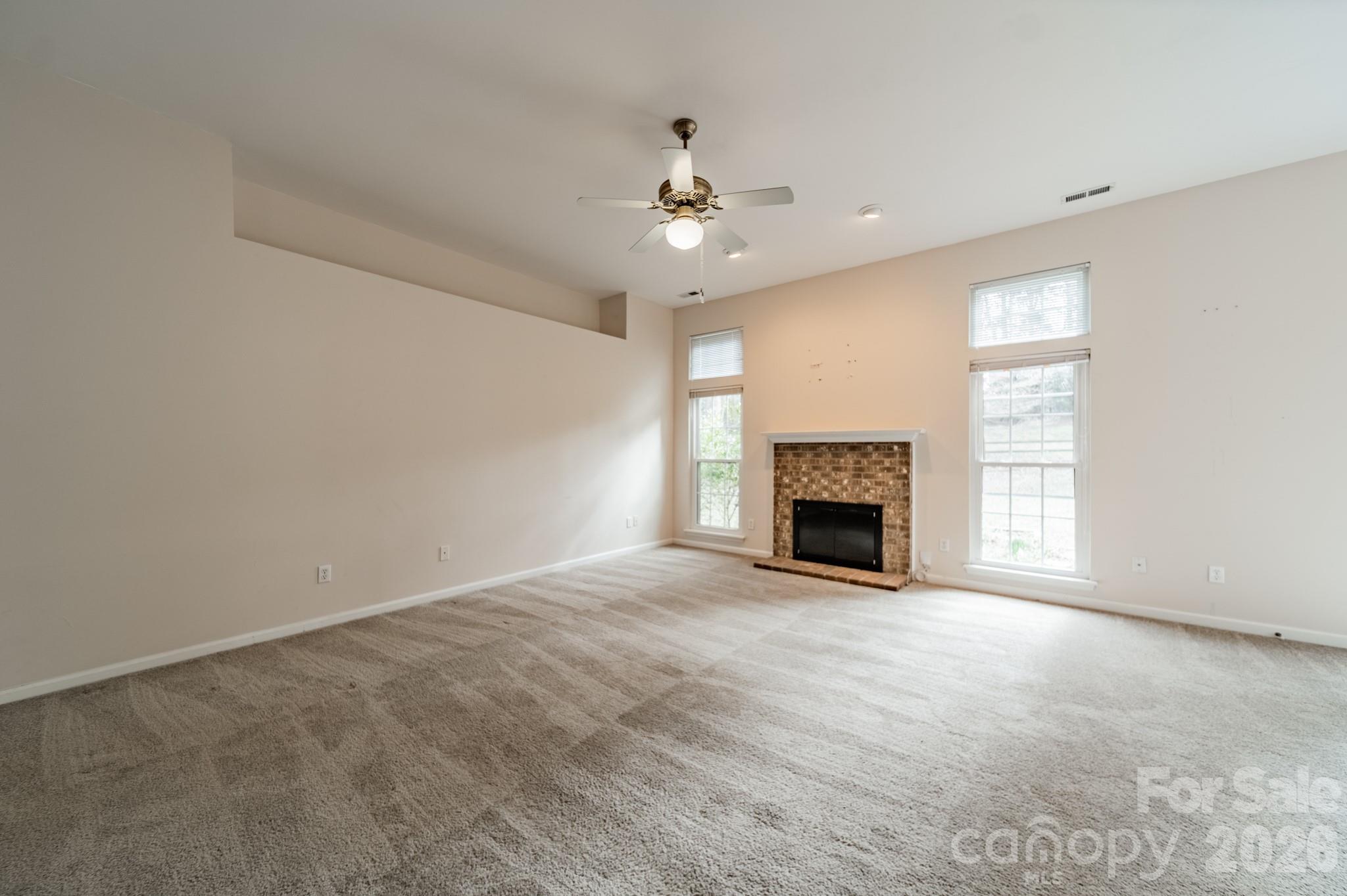 9409 Cedar River Road Huntersville, NC 28078 - Photo 10 of 31 a view of an empty room with a fireplace and a window