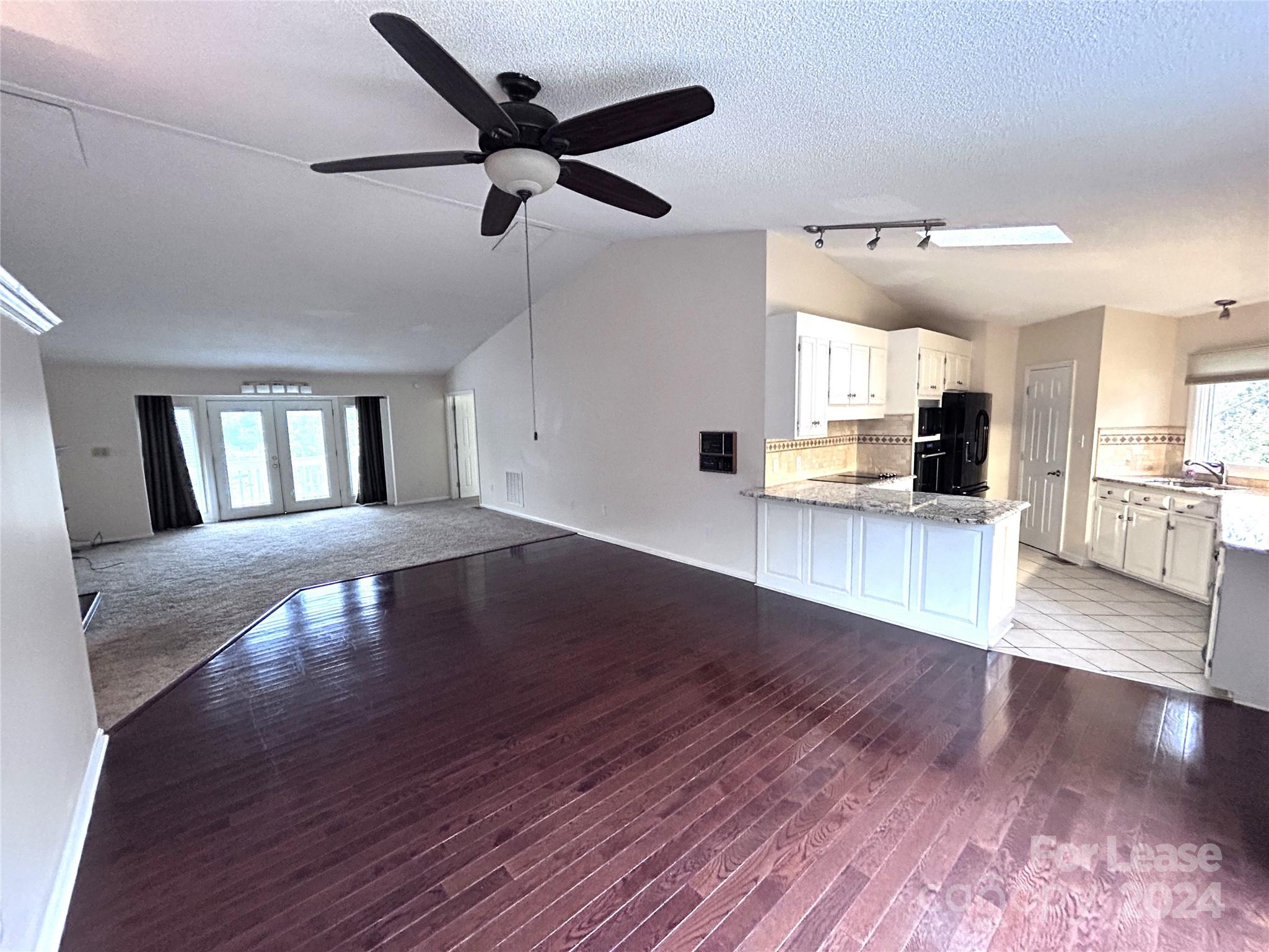 256 Spring Run Road Mooresville, NC 28117 - Photo 6 of 37 a view of a big room with wooden floor a ceiling fan and windows