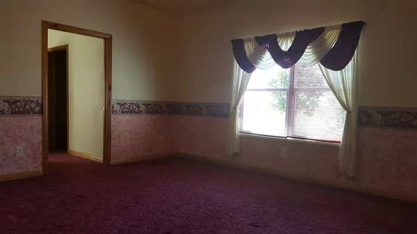 an empty room with windows and closet