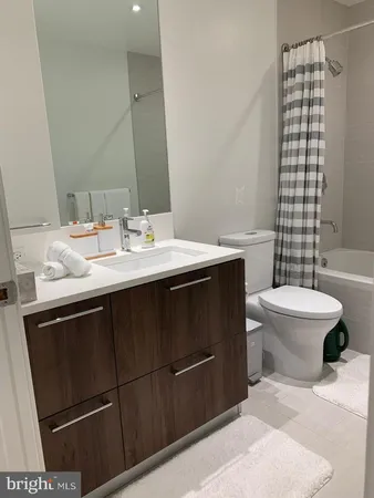 a bathroom with a sink a toilet a mirror and shower