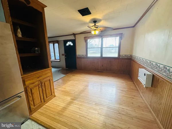a view of an empty room with window and wooden floor