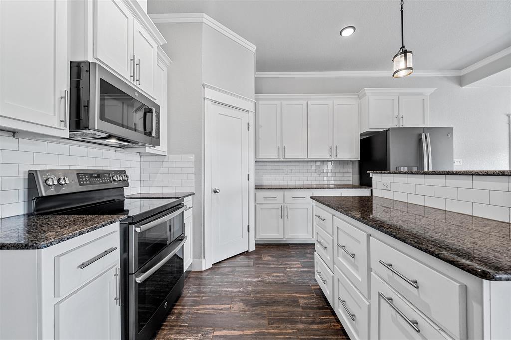 2662 Snow Road Kempner, TX 76539 - Photo 14 of 40 a kitchen with stainless steel appliances granite countertop a sink a stove a microwave and wooden cabinets