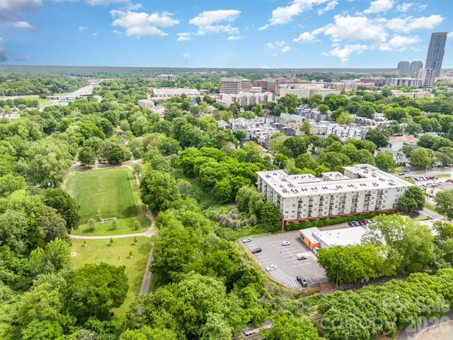 an aerial view of residential house with outdoor space and trees all around