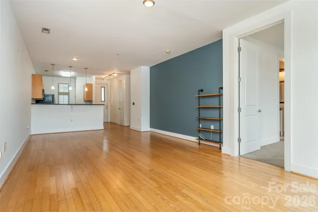 a view of a kitchen with wooden floor and a window