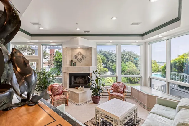a living room with furniture a fireplace and a floor to ceiling window