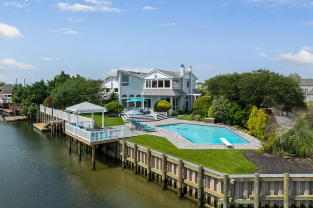 a view of a house with pool and chairs