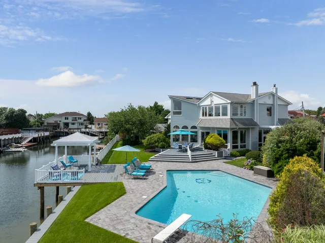 a view of a house with pool and chairs
