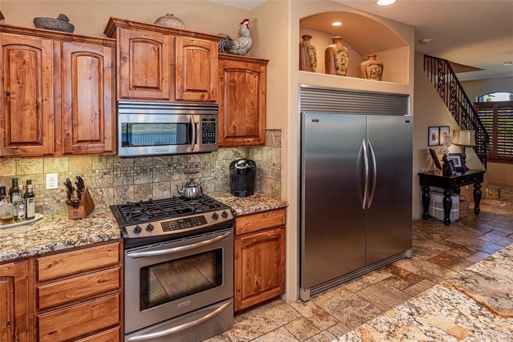 4654 My Place Road Needles, CA 92363 - Photo 17 of 75 a kitchen with granite countertop a refrigerator stove and cabinets