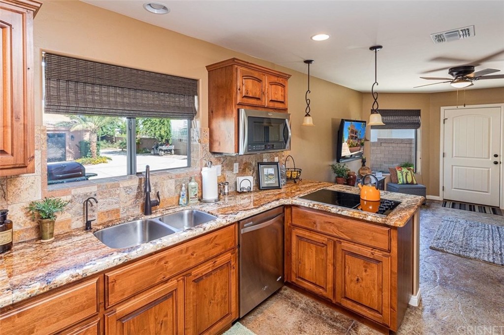 4654 My Place Road Needles, CA 92363 - Photo 54 of 75 a kitchen with stainless steel appliances granite countertop a sink a stove and a wooden cabinets