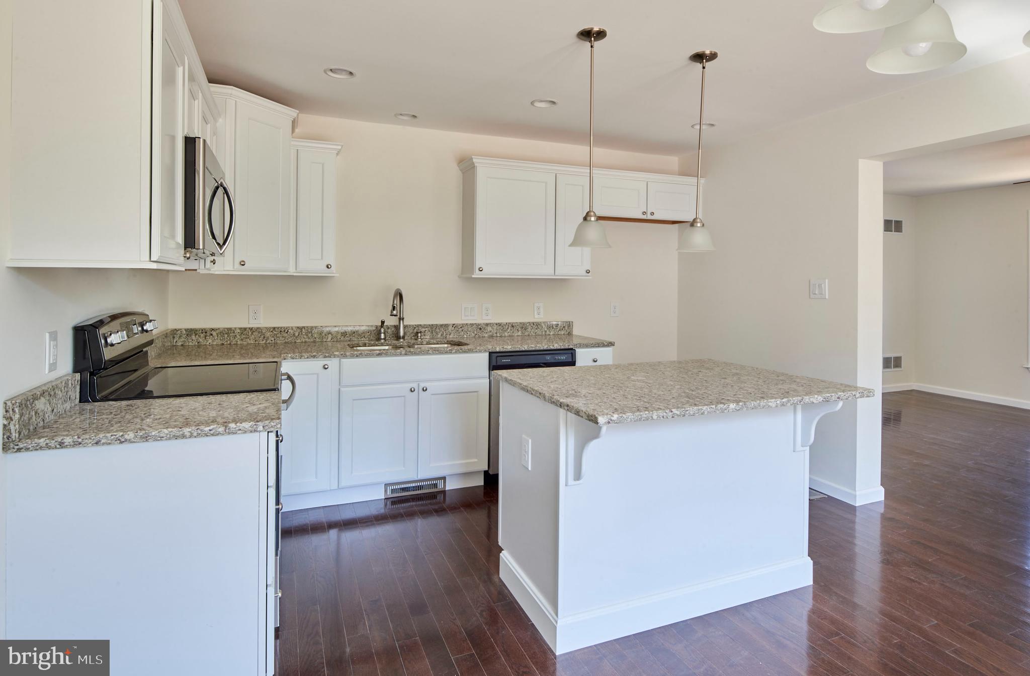 192 Timberwood Trail Centre Hall, PA 16828 - Photo 6 of 20 a kitchen with stainless steel appliances granite countertop a sink a stove a refrigerator and island with wooden floor