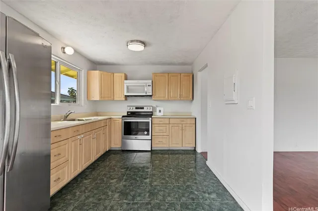 a kitchen with granite countertop white cabinets and stainless steel appliances
