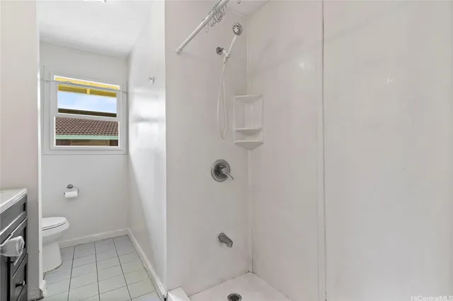 a bathroom with a granite countertop shower a toilet and a sink