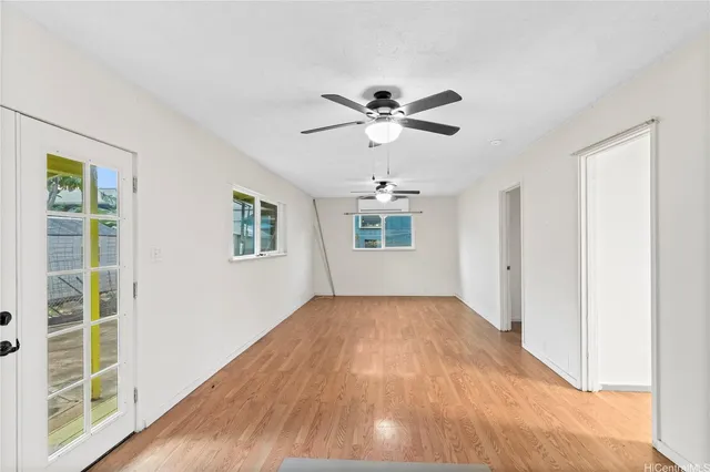 a view of empty room with wooden floor and fan